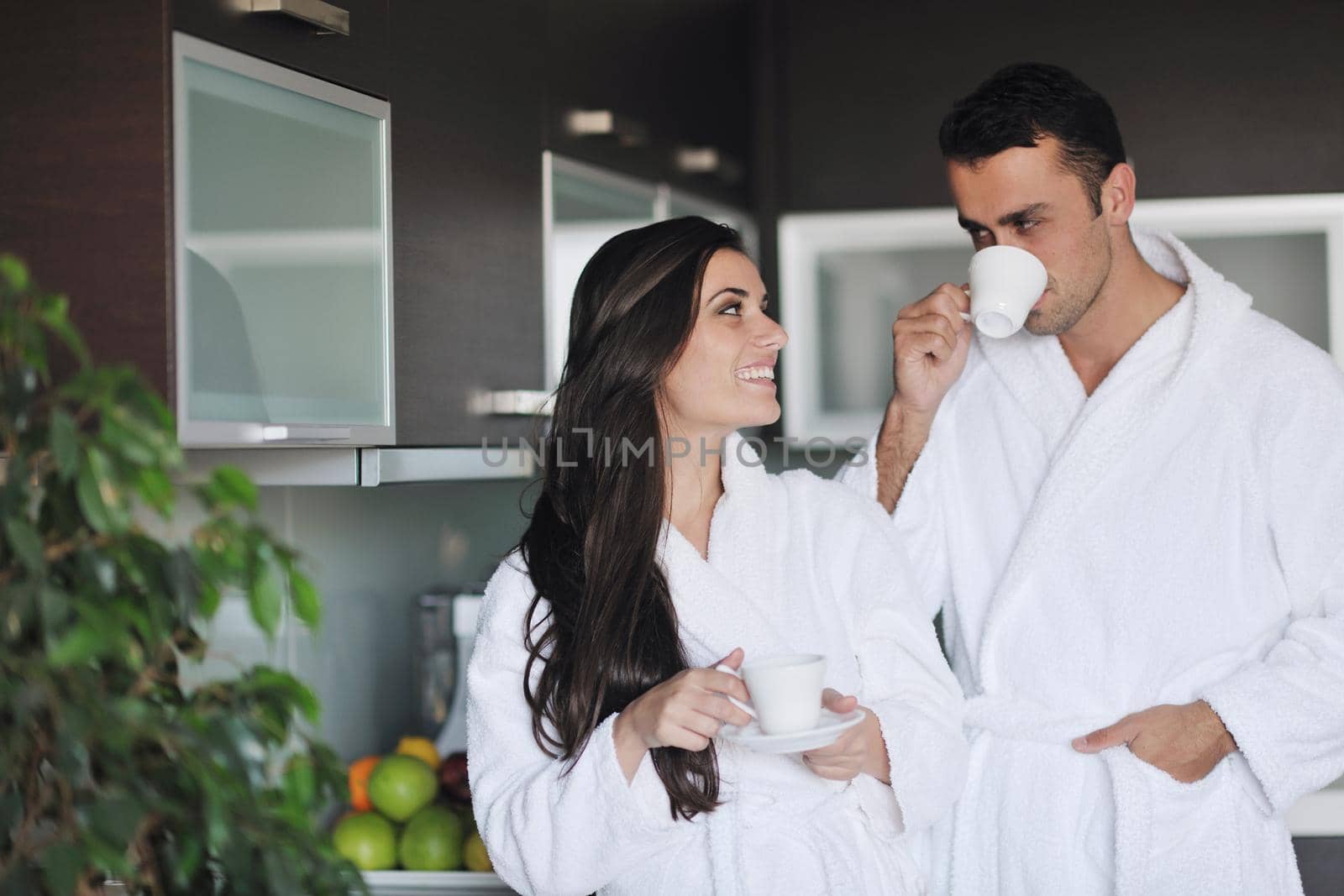 Young love couple taking fresh morning cup of coffee in the modern appartment