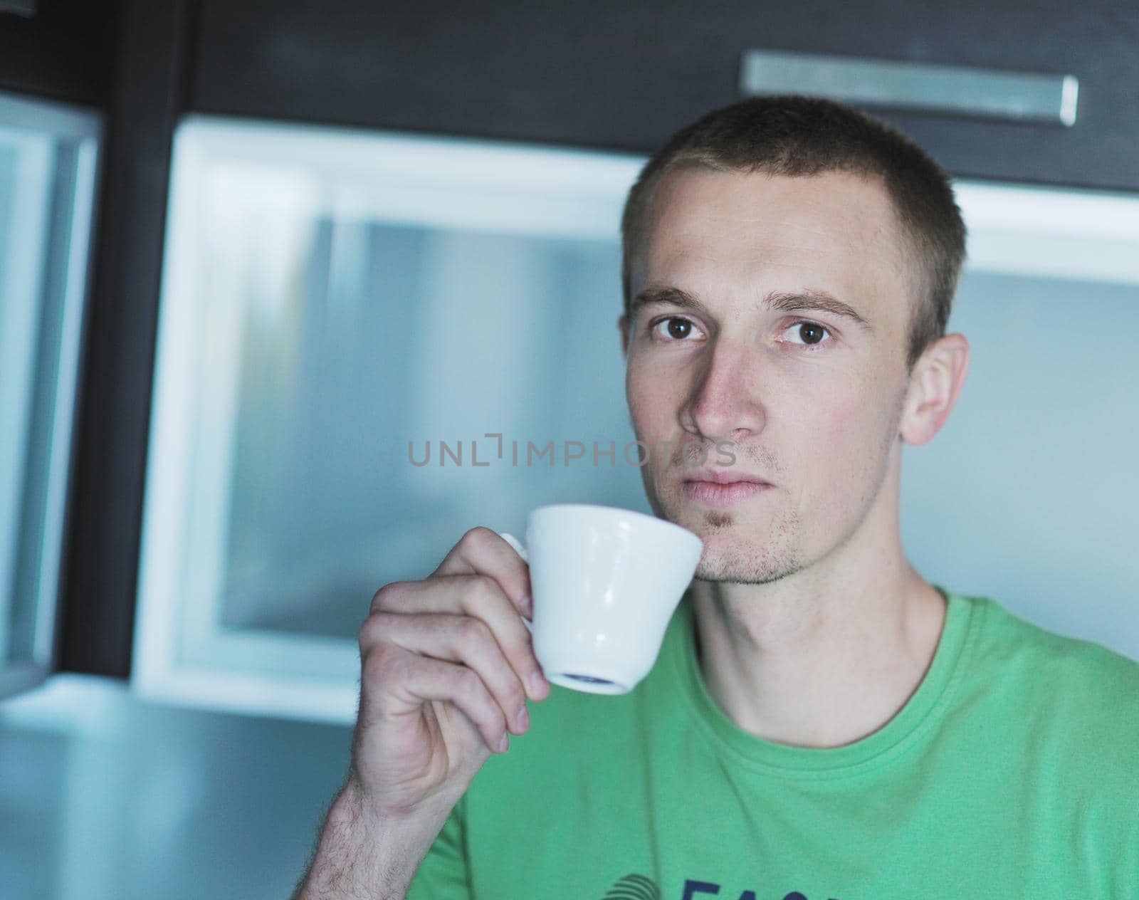 handsome young man drink fresh morning coffee from white cup