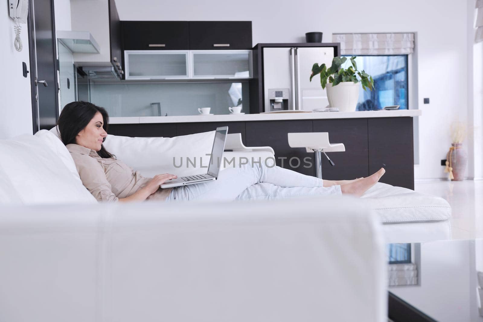 relaxed young woman working on laptop computer in bright  home indoor
