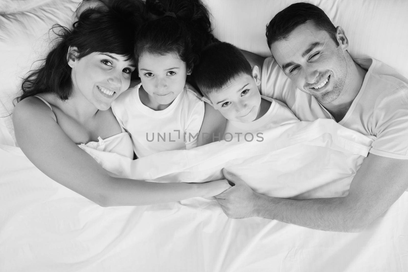 happy young Family in their bedroom have fun and play in bed