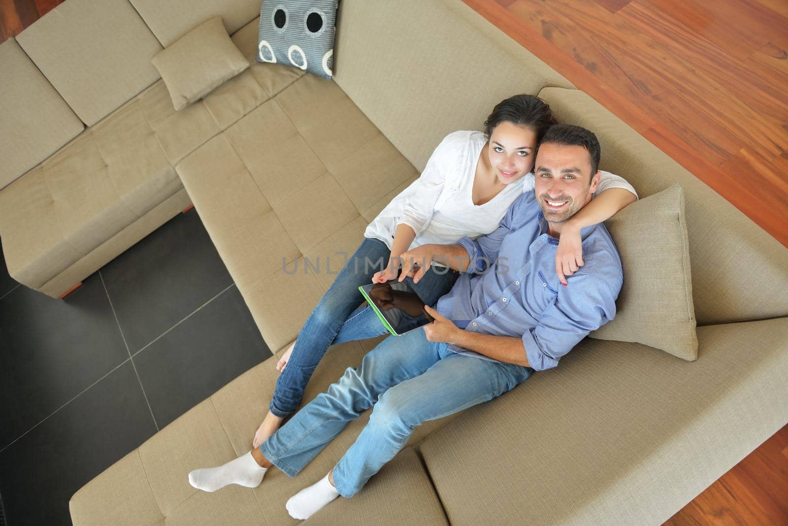 couple at home using tablet computer by dotshock