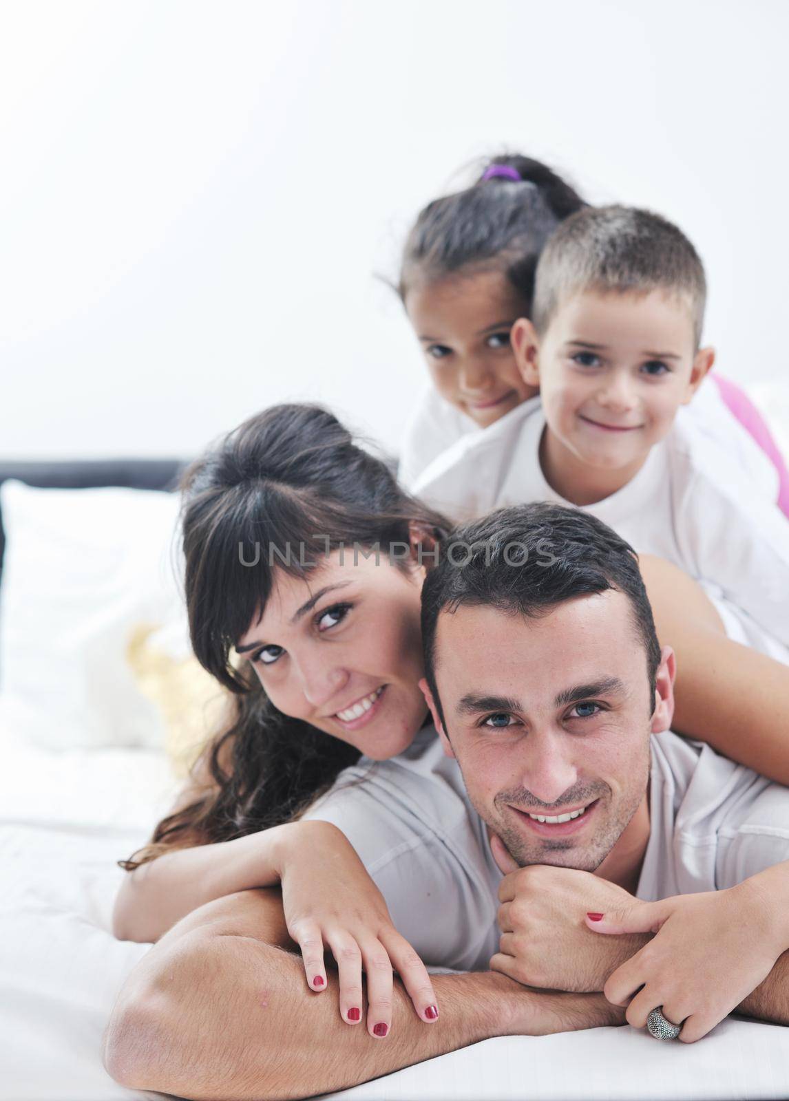 happy young Family in their bedroom have fun and play in bed