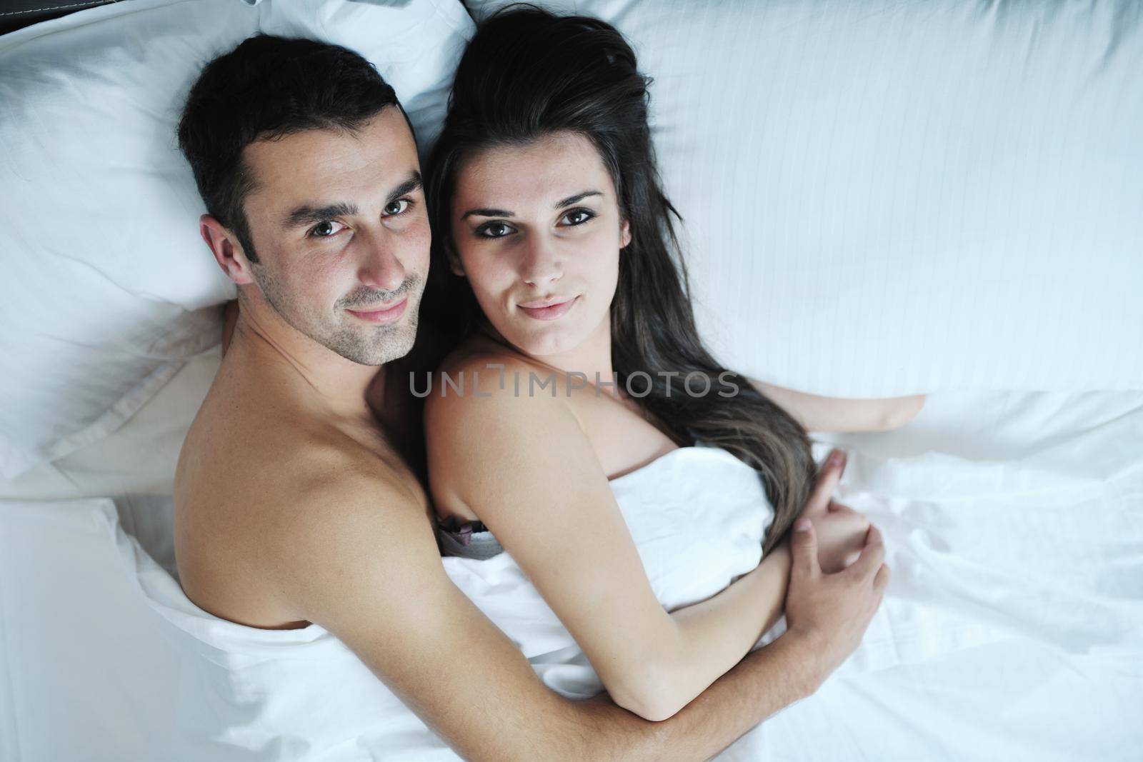 happy young healthy people  couple have good time in their bedroom make love and sleep