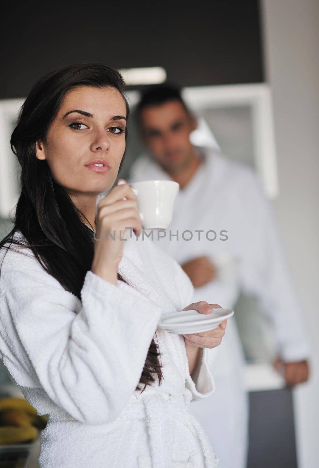 Young love couple taking fresh morning cup of coffee in the modern appartment