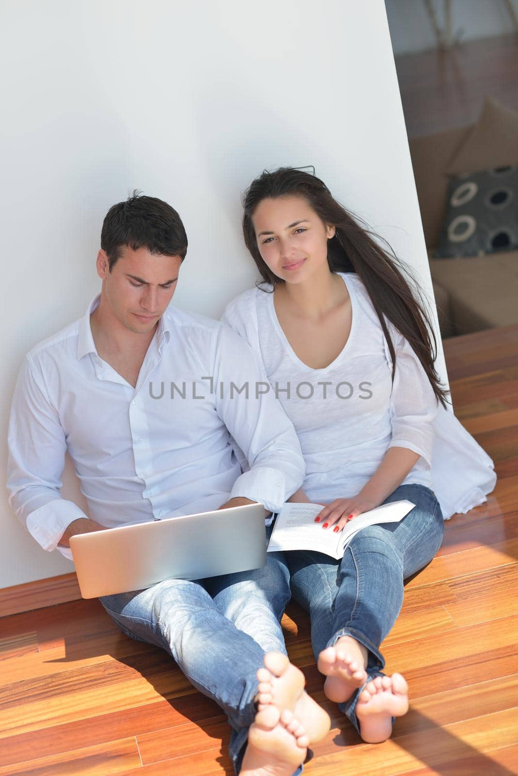young couple using laptop at home by dotshock