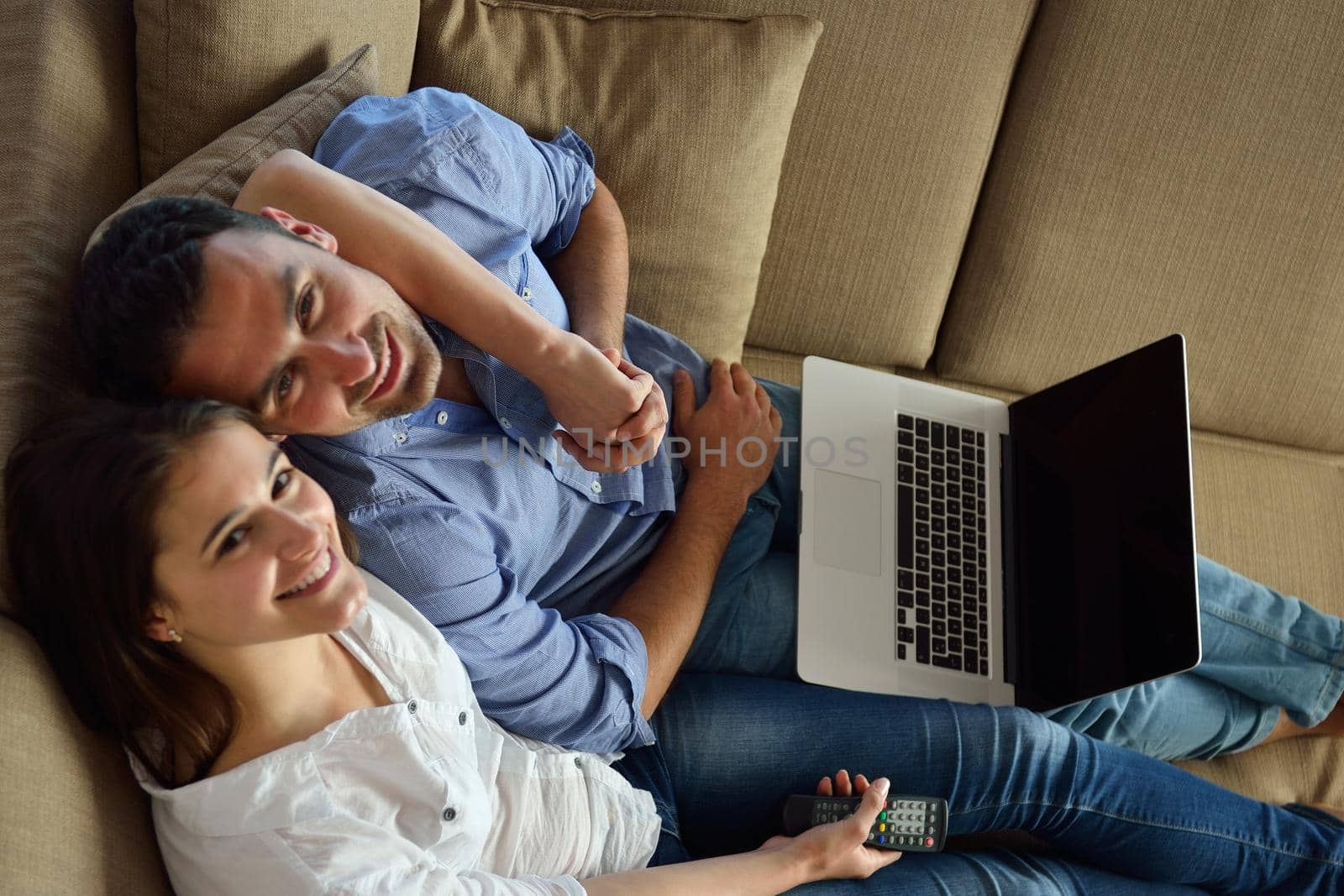 happy young relaxed  couple working on laptop computer at modern home indoor