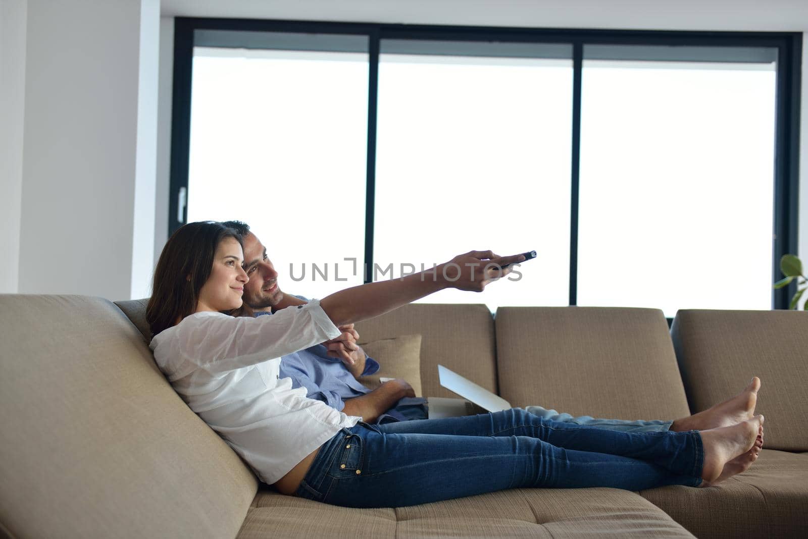 Couple on sofa with TV remote