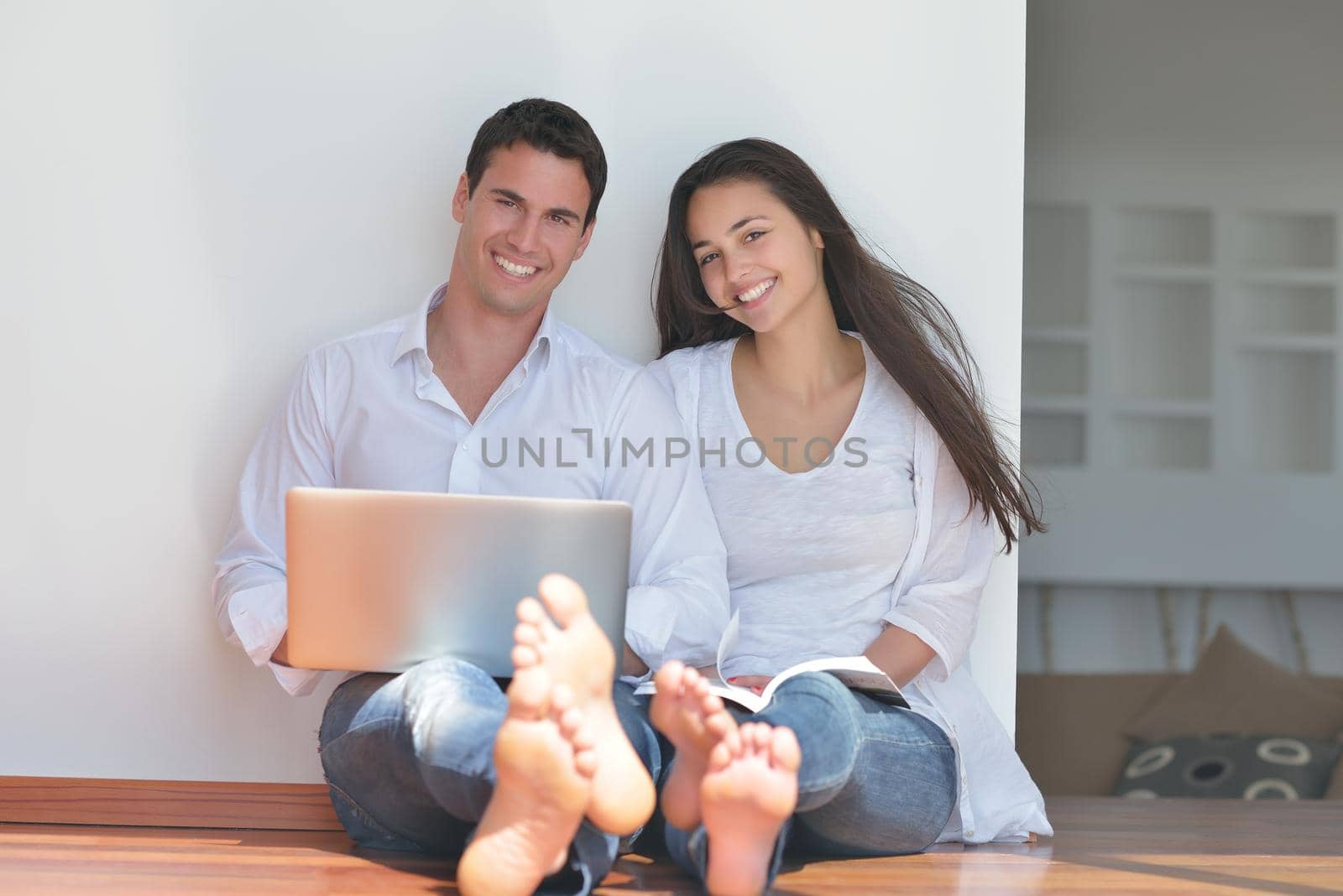 young couple using laptop at home by dotshock