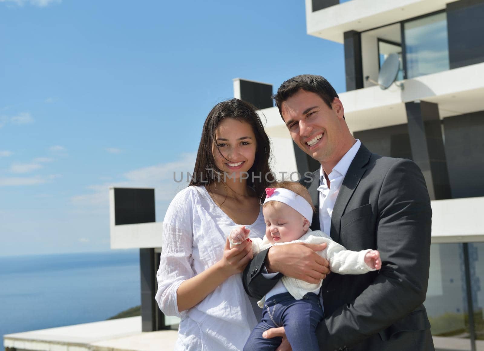 happy young family couple with beautiful new born baby have fun at home