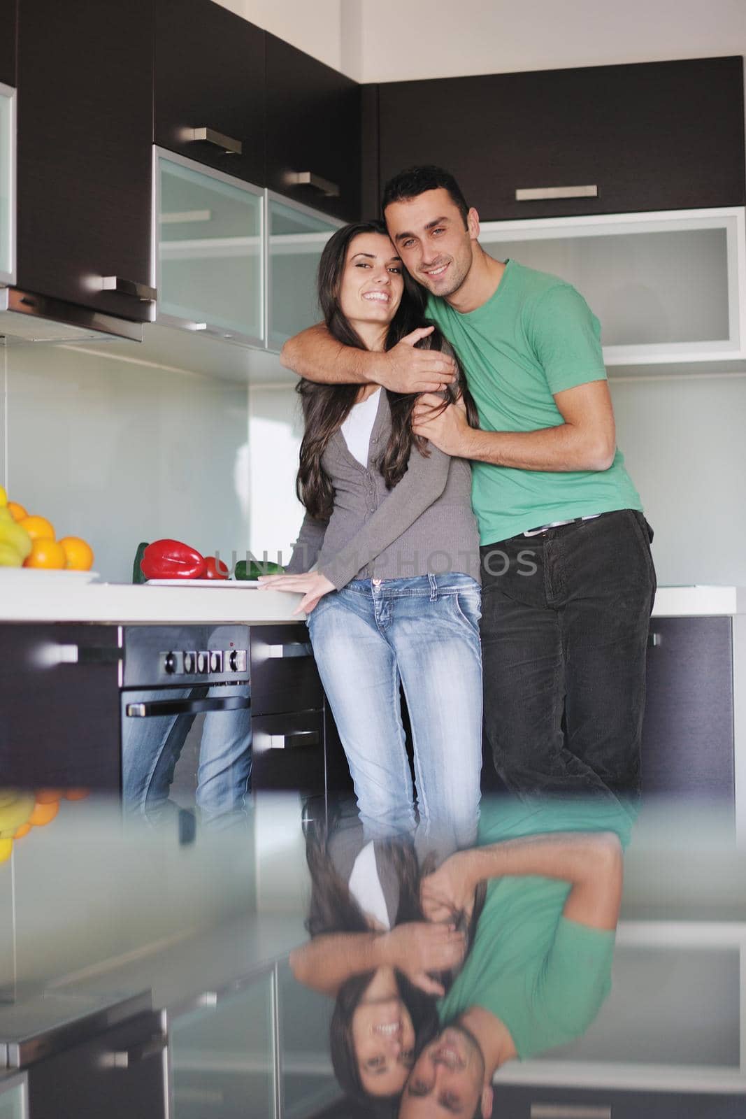 happy young couple have fun in  modern kitchen indoor  while preparing fresh fruits and vegetables food salad