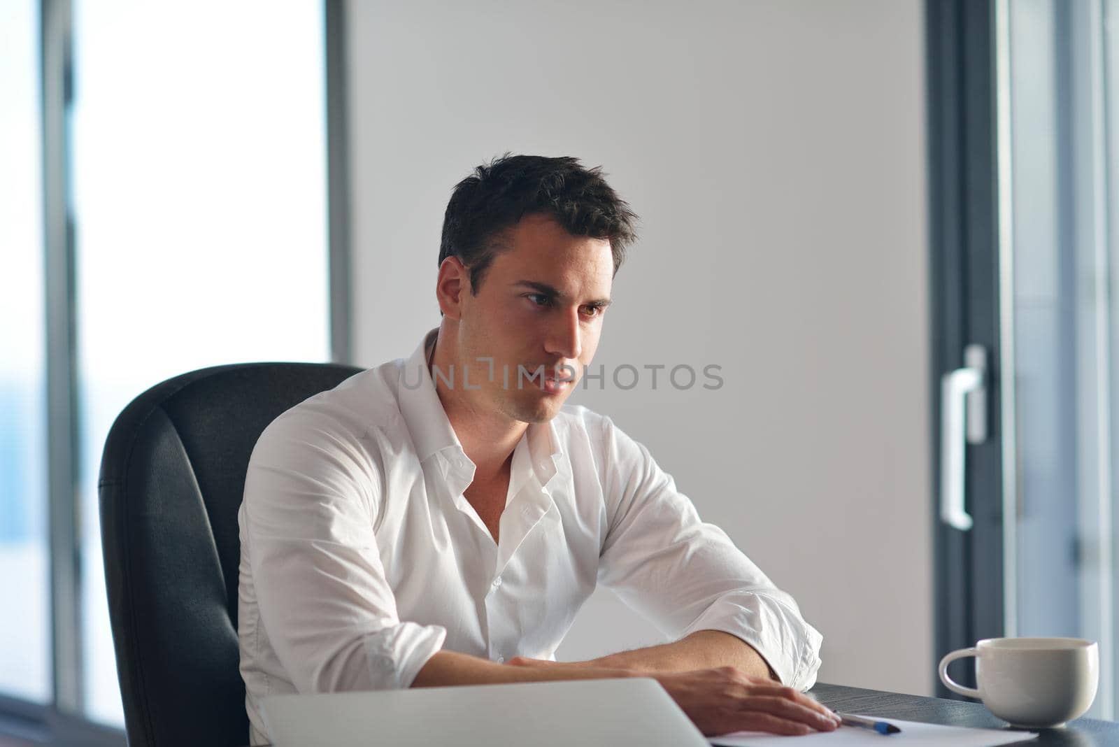 frustrated young business man working on laptop computer at home by dotshock