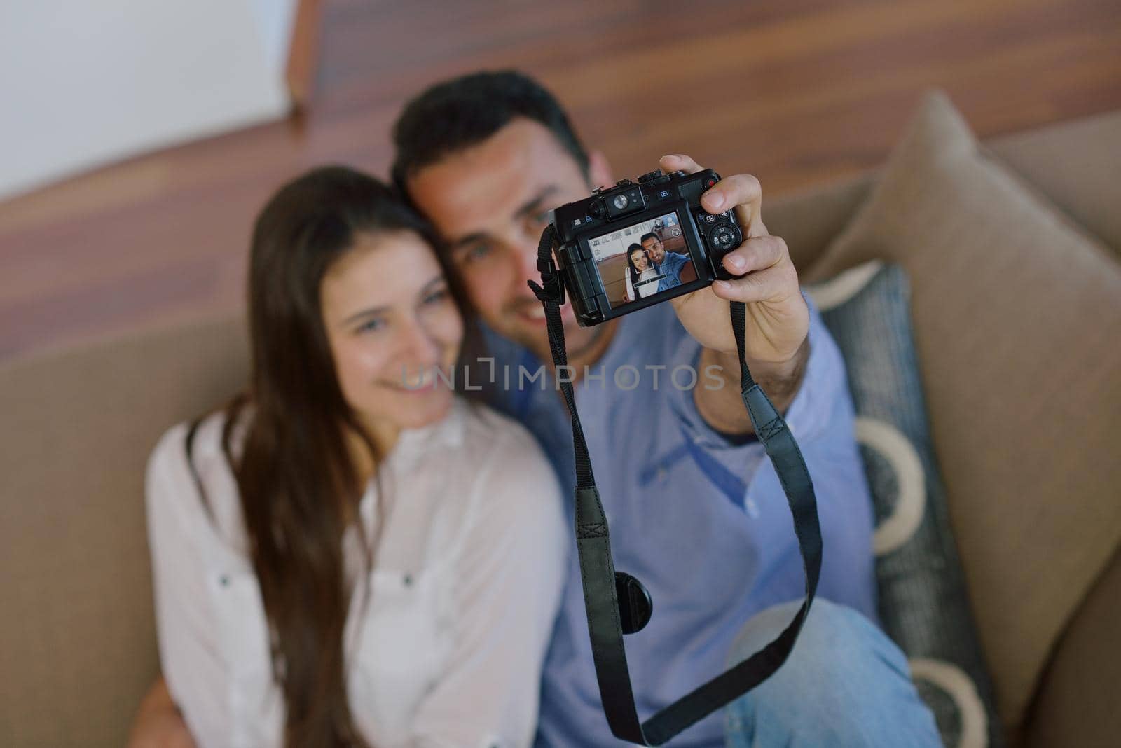 happy young  couple playing with digital camera at home