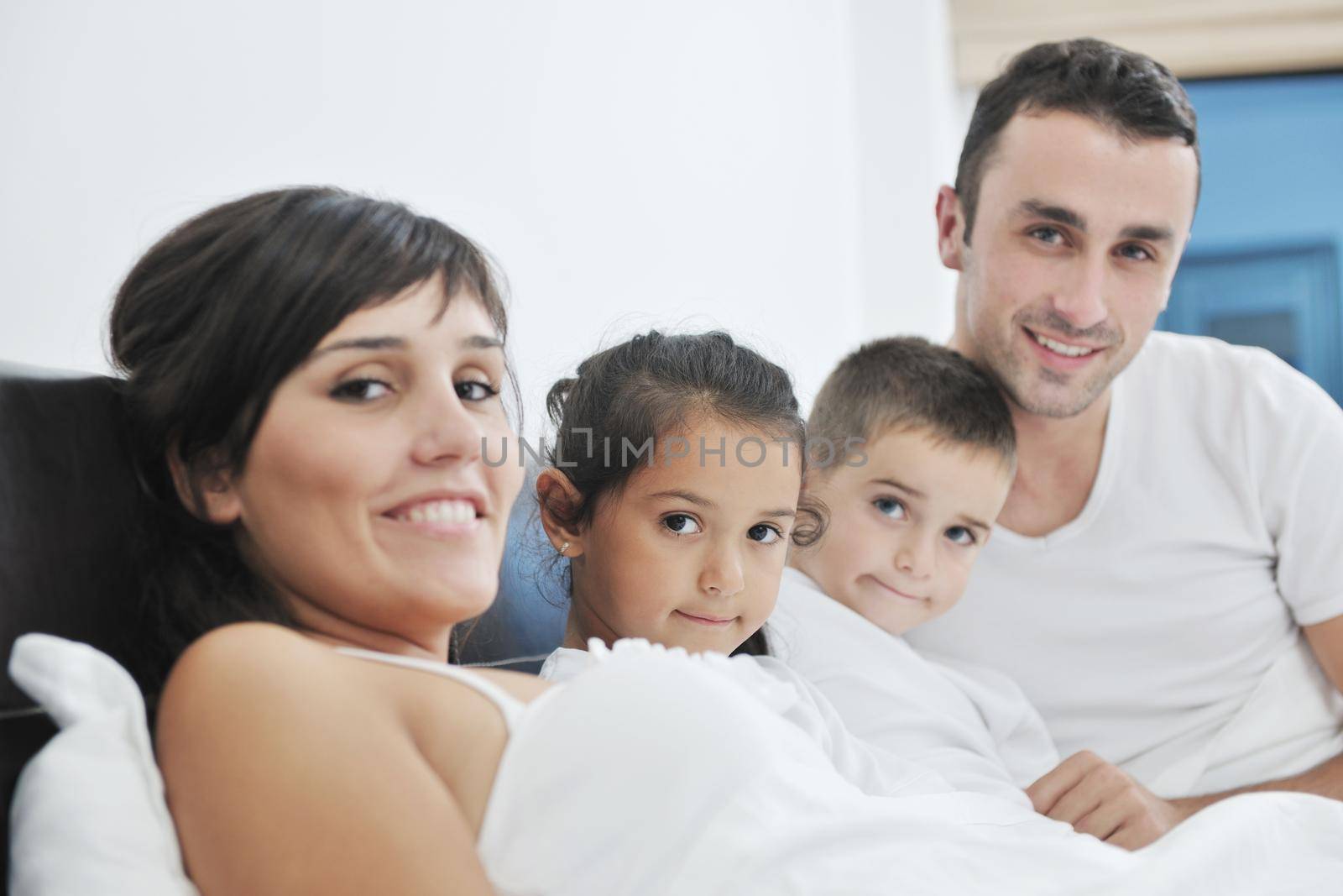 happy young Family in their bedroom have fun and play in bed