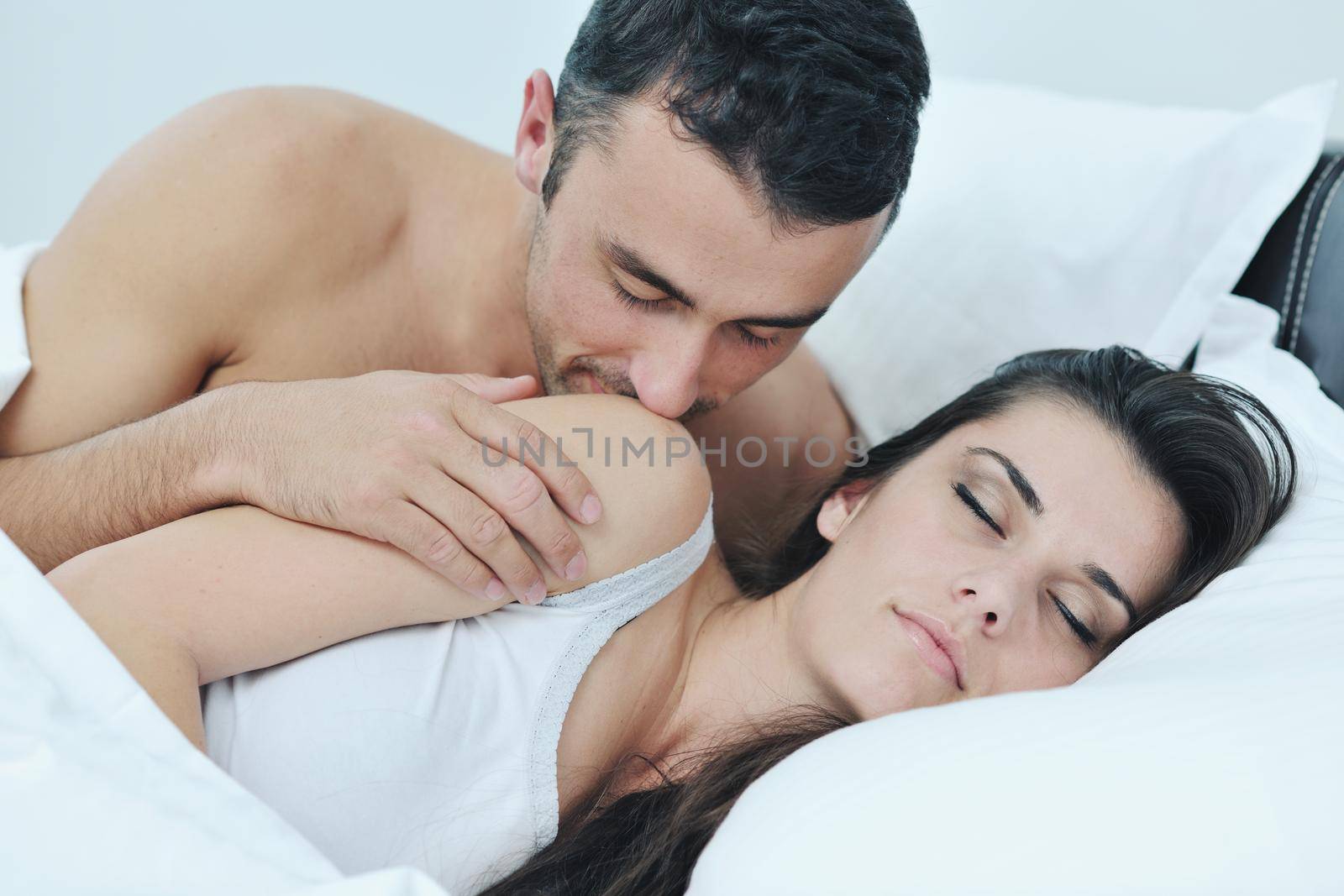 happy young healthy people  couple have good time in their bedroom make love and sleep