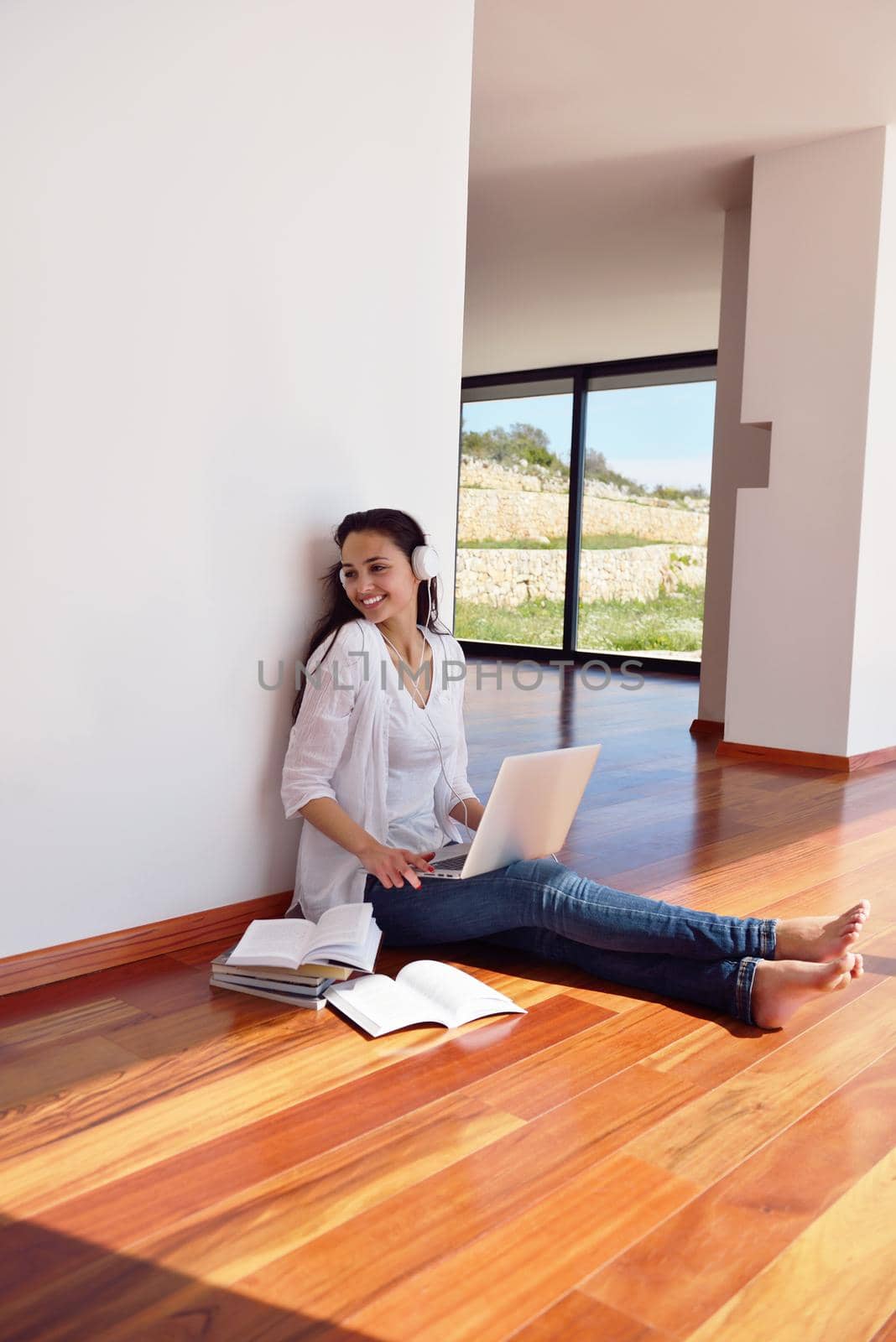 relaxed young woman at home working on laptop by dotshock