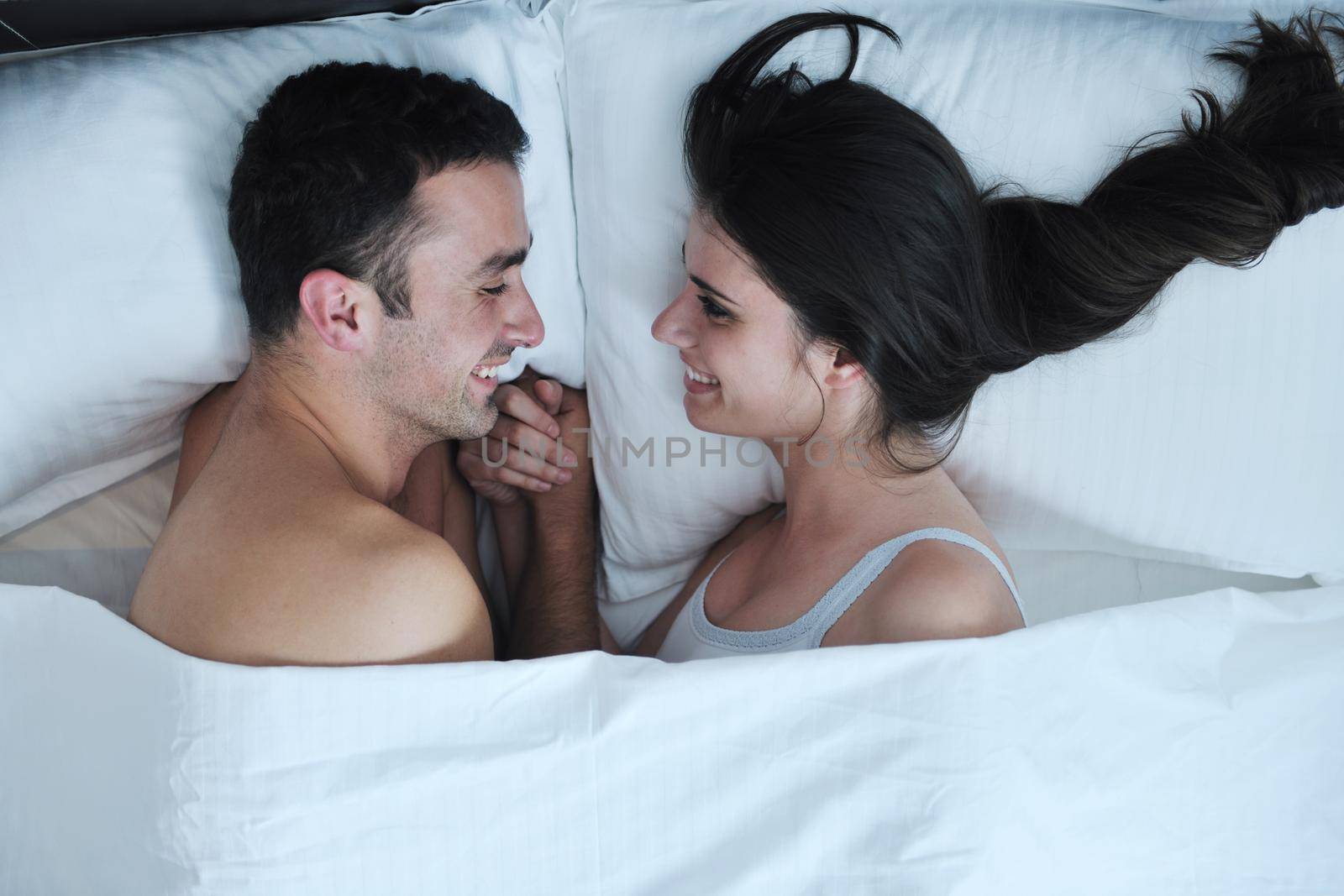 happy young healthy people  couple have good time in their bedroom make love and sleep