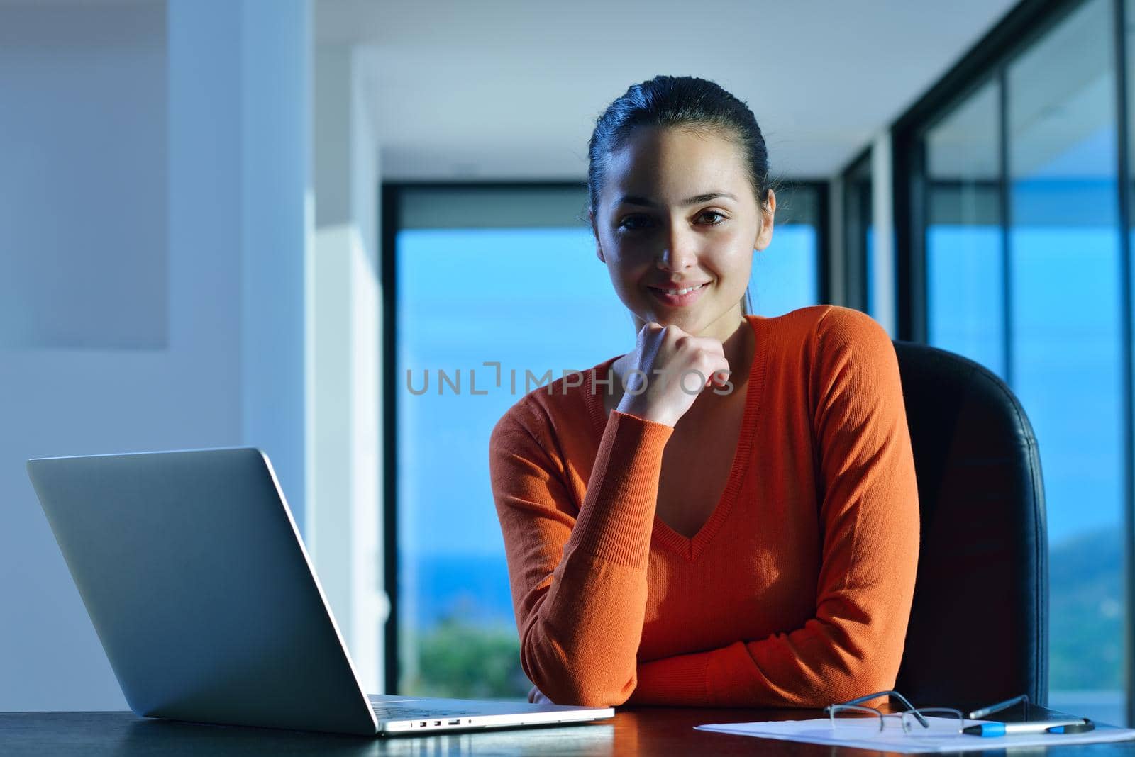 beautiful young woman relax and work on laptop computer while listening music on heaphones and read book at home