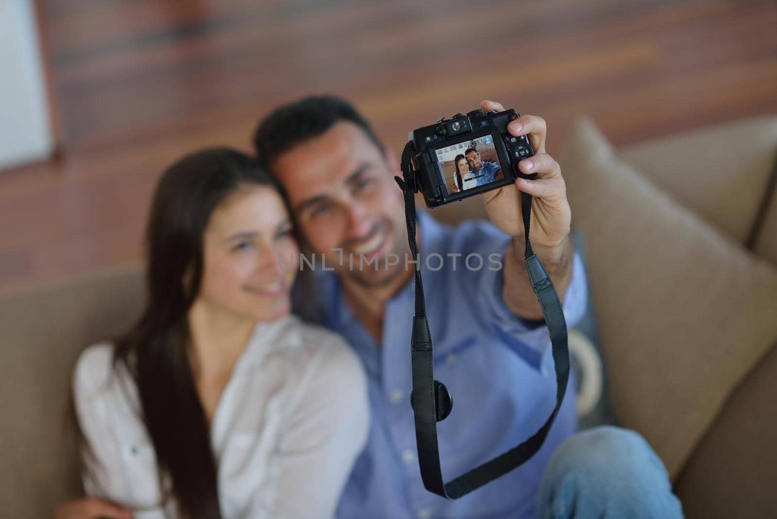 happy young  couple playing with digital camera at home