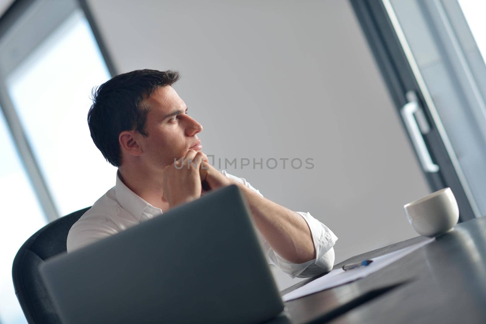 portrait of young happy business man working on laptop computer at home