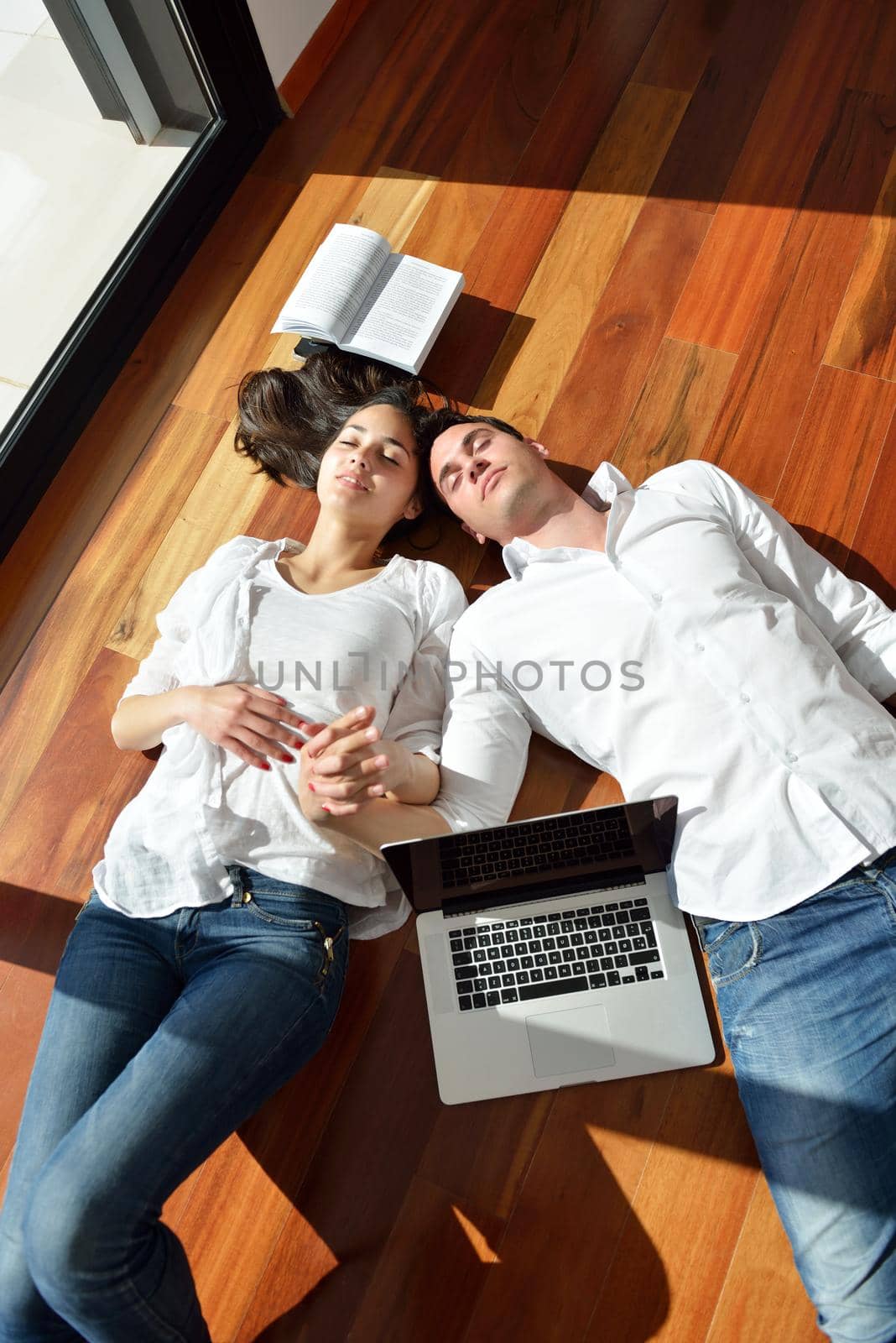 happy young relaxed  couple working on laptop computer at modern home indoor