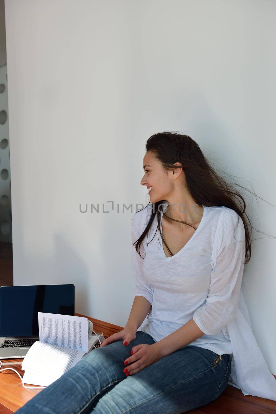 relaxed young woman at home working on laptop by dotshock