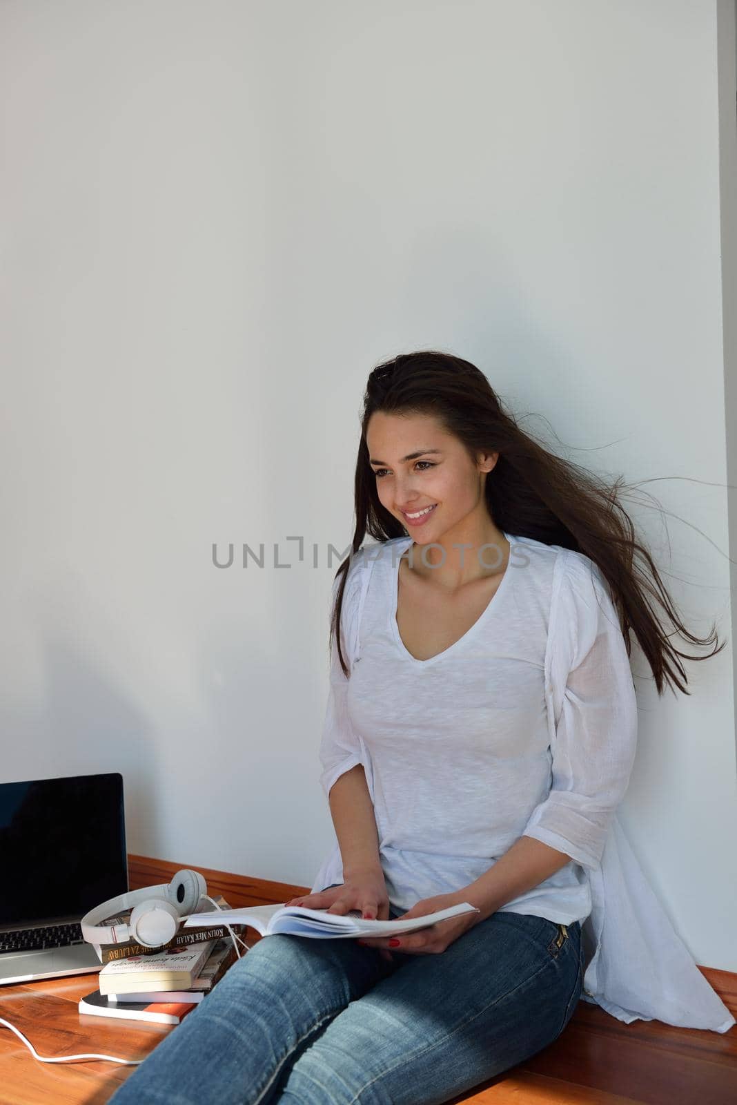 beautiful young woman relax and work on laptop computer while working on laptop computer and read book at home