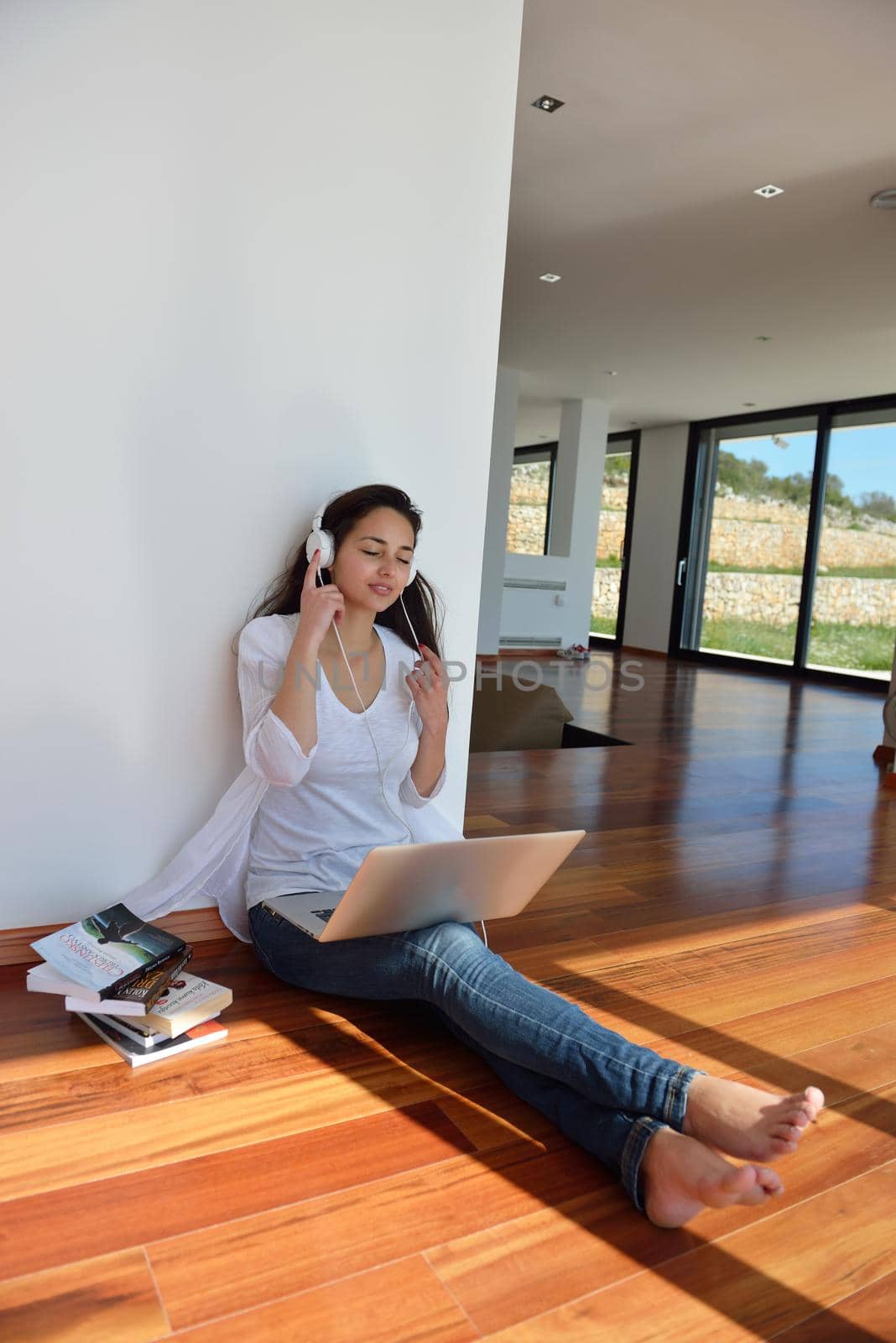 relaxed young woman at home working on laptop by dotshock