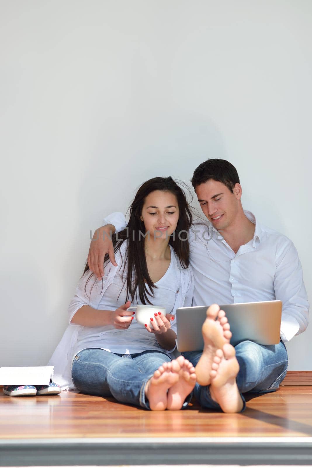 happy young relaxed  couple working on laptop computer at modern home indoor