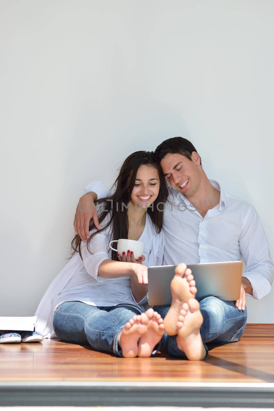 happy young relaxed  couple working on laptop computer at modern home indoor