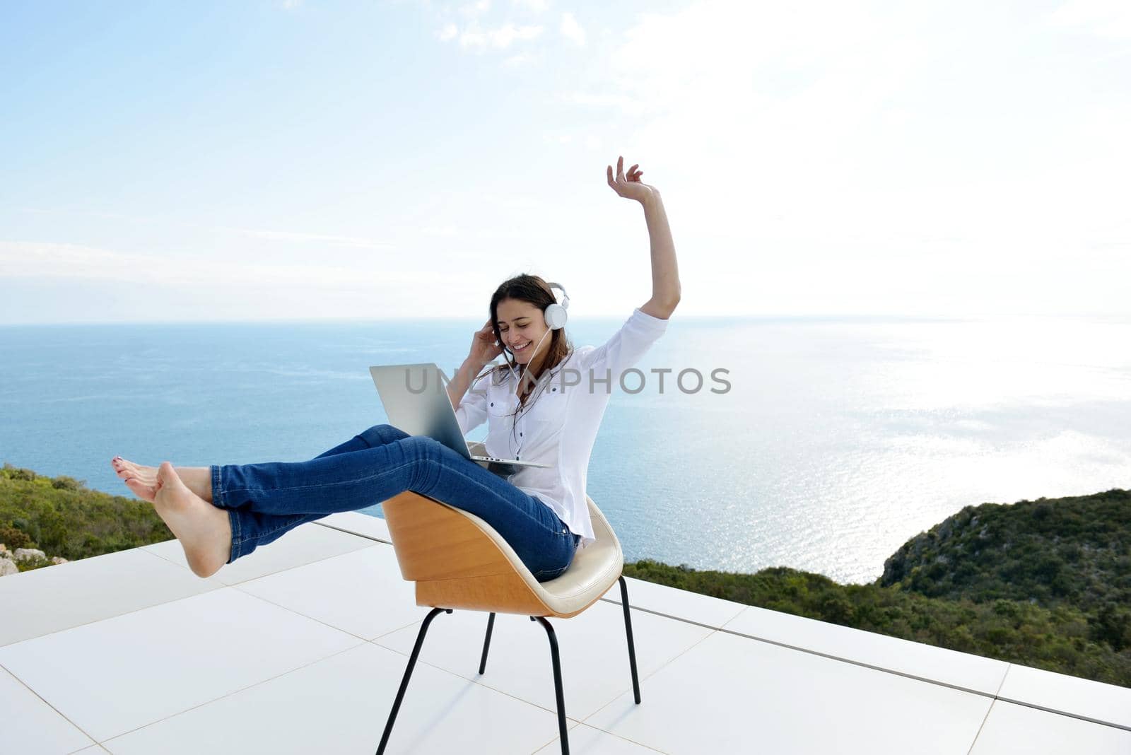 relaxed young woman at home working on laptop by dotshock