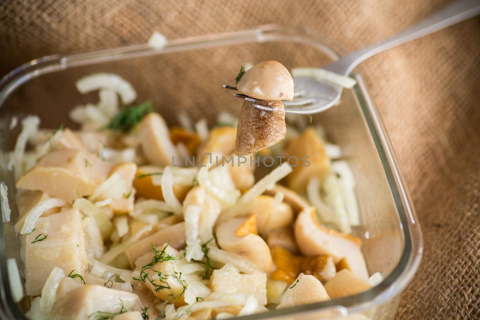 natural organic wild mushrooms marinated with onions in a glass bowl on the table