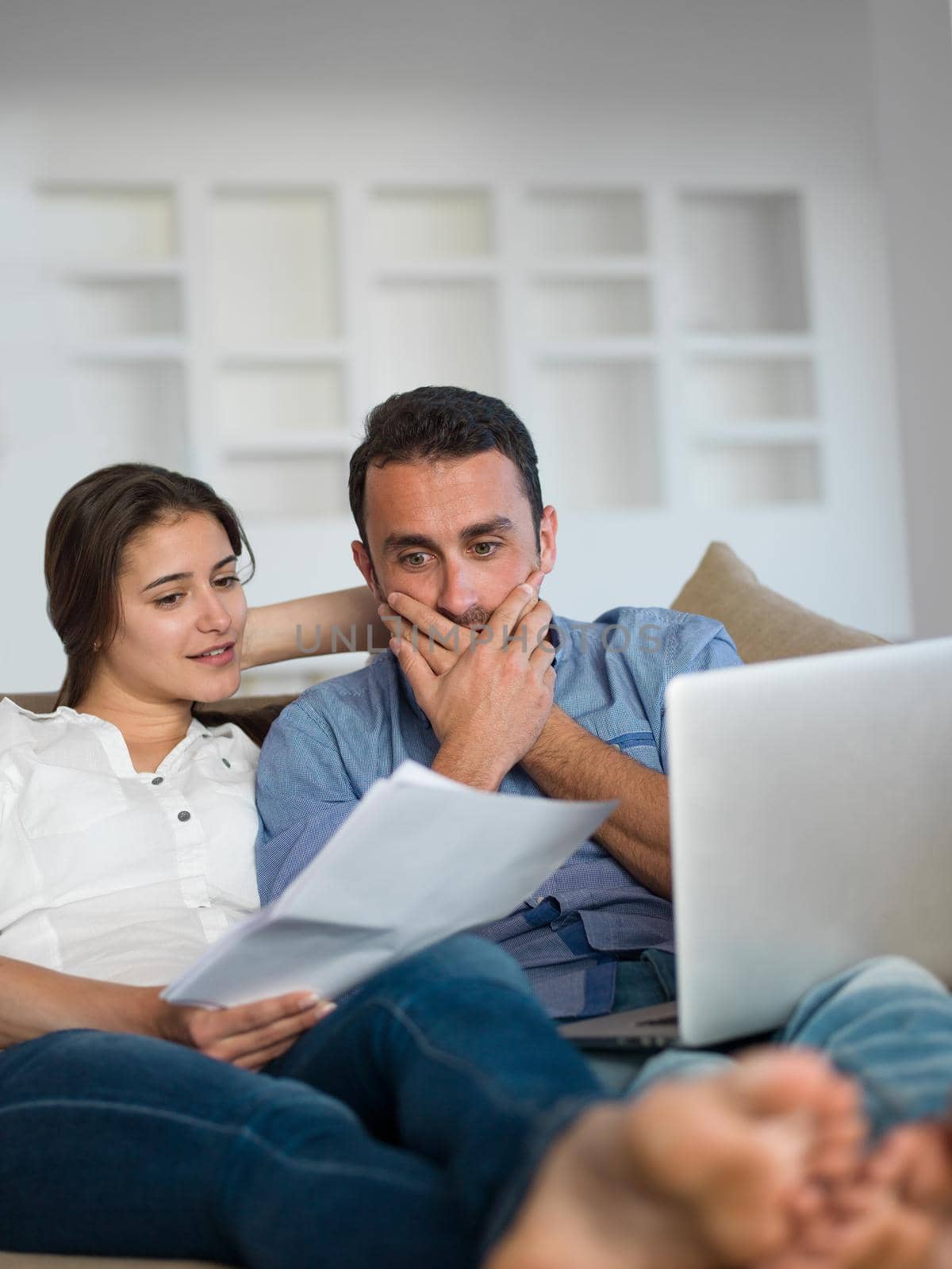 happy young relaxed  couple working on laptop computer at modern home indoor