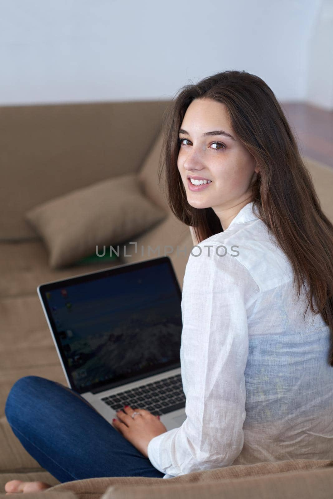 beautiful young woman relax and work on laptop computer modern  home office while listening musin on white headphones