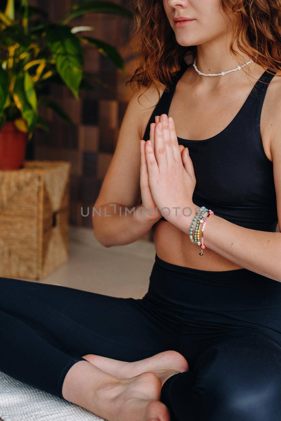 A young woman in black clothes is doing yoga in a modern gym.The concept of health.