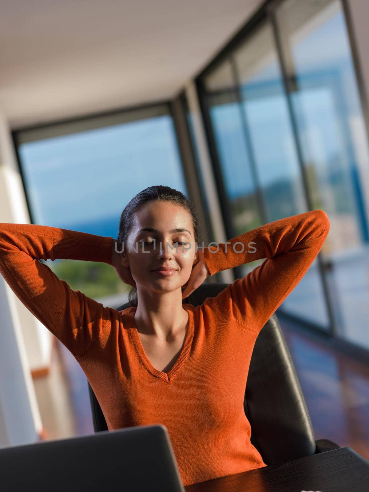 relaxed young woman at home working on laptop computer by dotshock