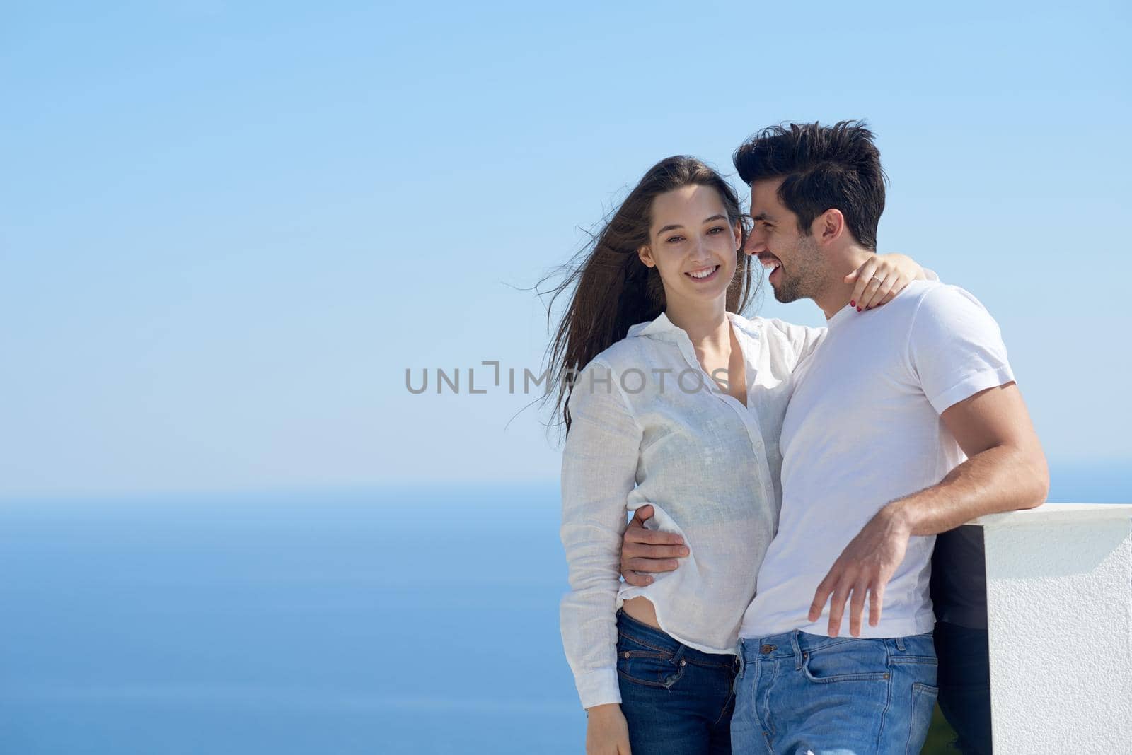 happy young romantic couple have fun relax smile at modern home outdoor terace balcony terace