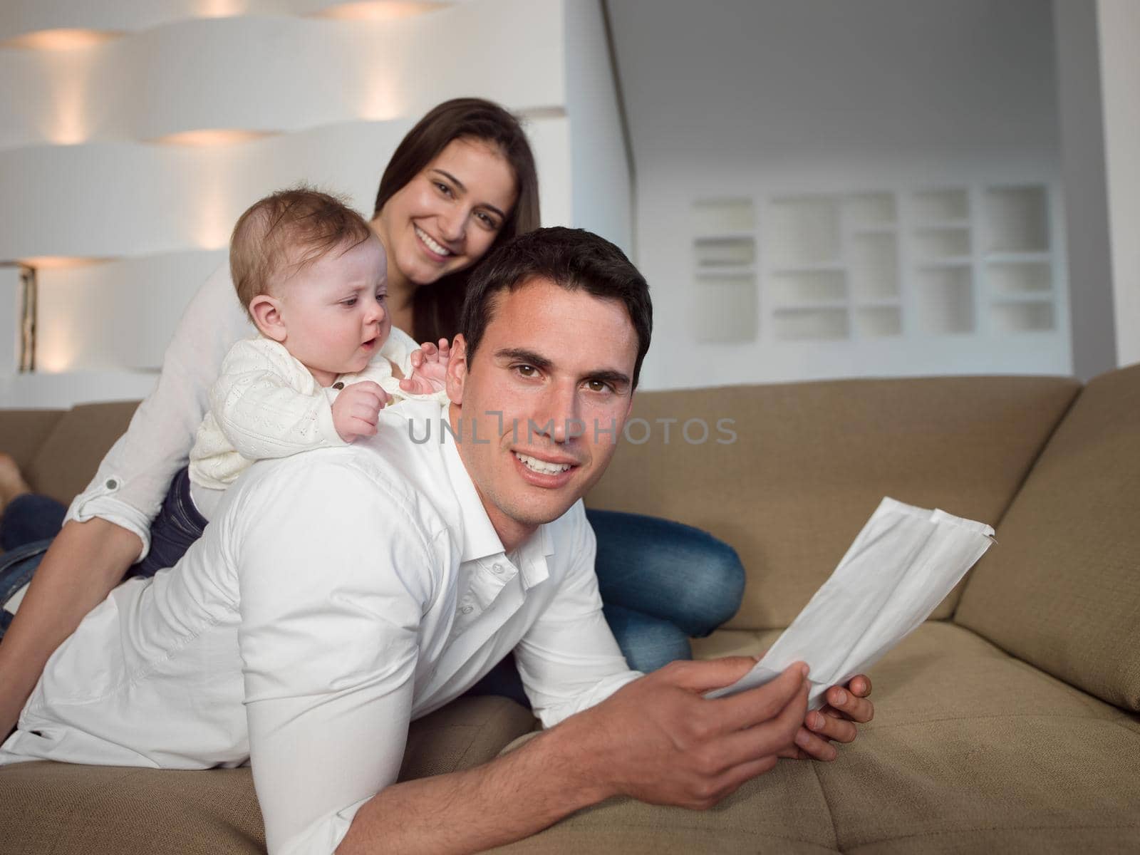 happy young family couple with beautiful new born baby have fun at modern  home