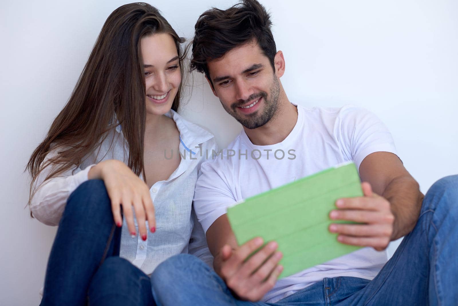 couple at modern home using tablet computer by dotshock