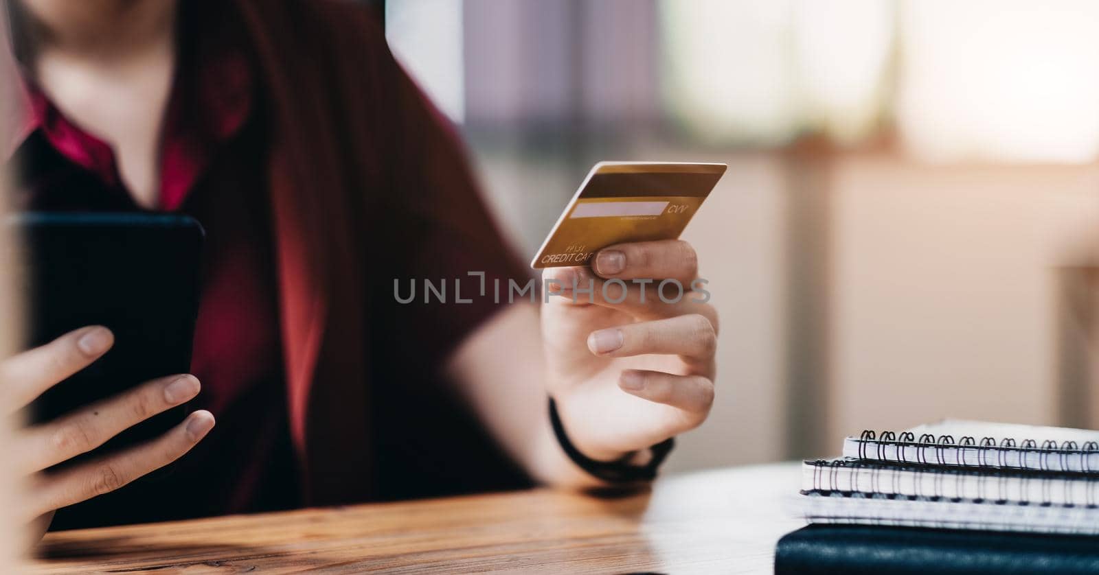 Woman using credit card and mobile phone for online shopping and internet payment via mobile banking application.