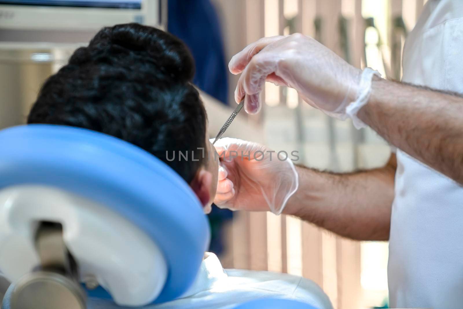 The dentist examines the patient's teeth, close-up.