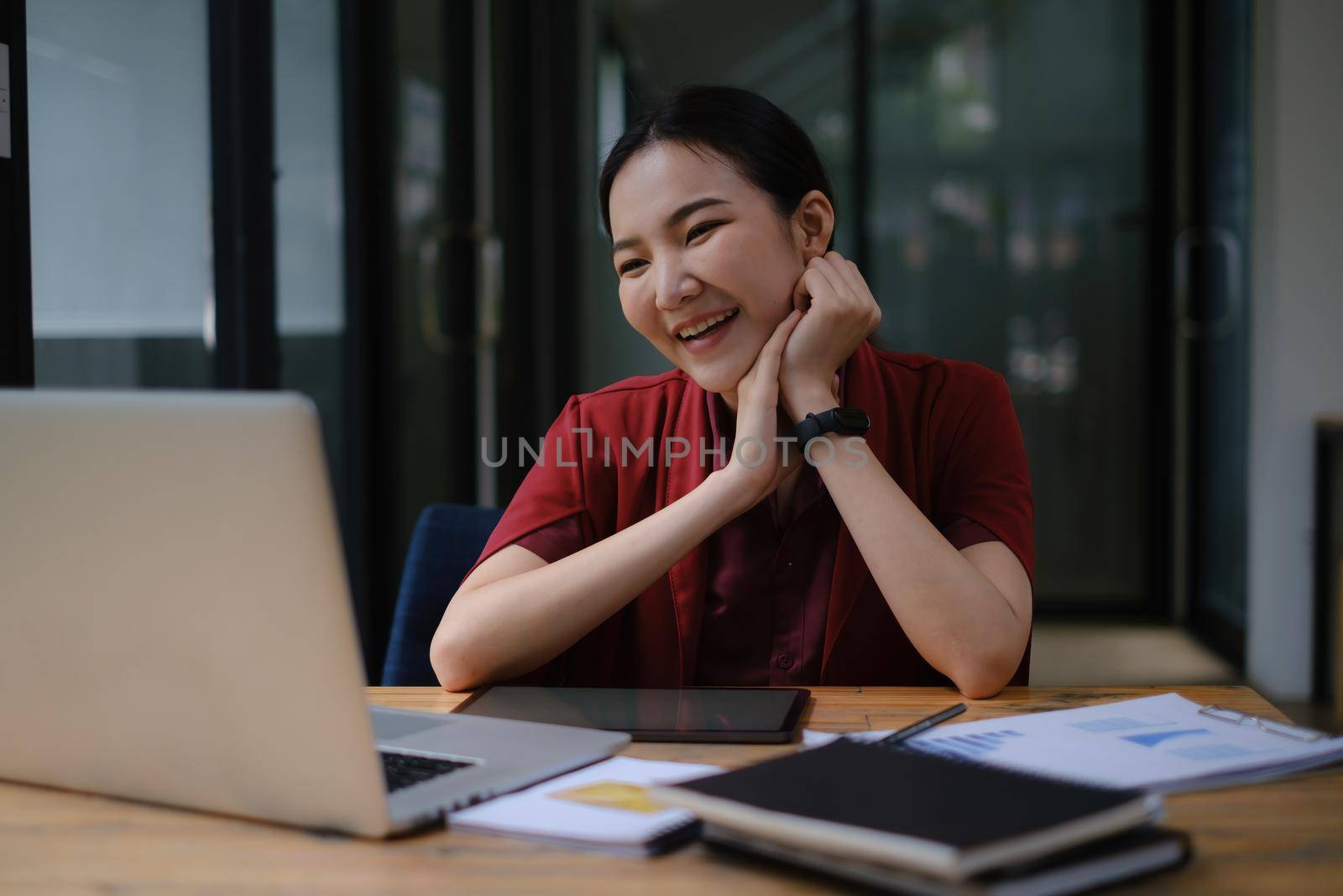 A happy woman has a business meeting with her team through video call In a cafe