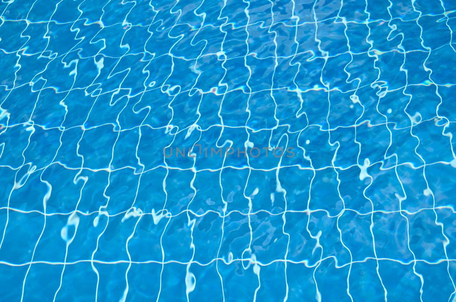 pool bottom visible through clear blue and transparent water with ripples