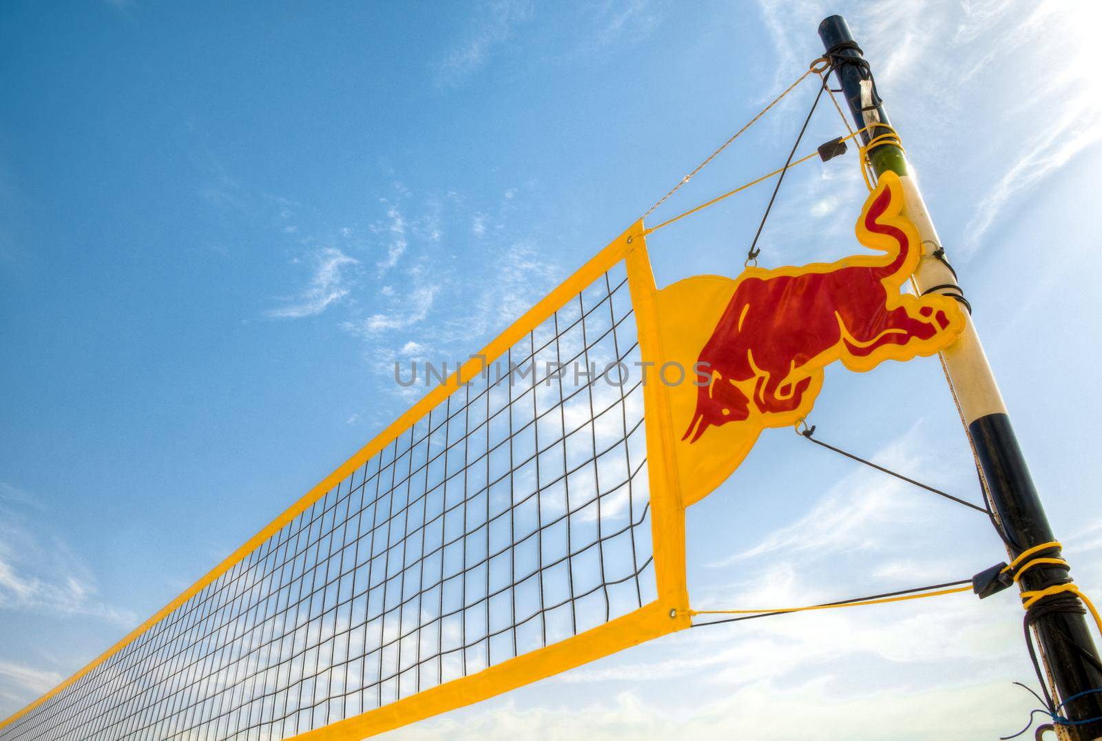 yellow volleyball net against blue cloudy sky