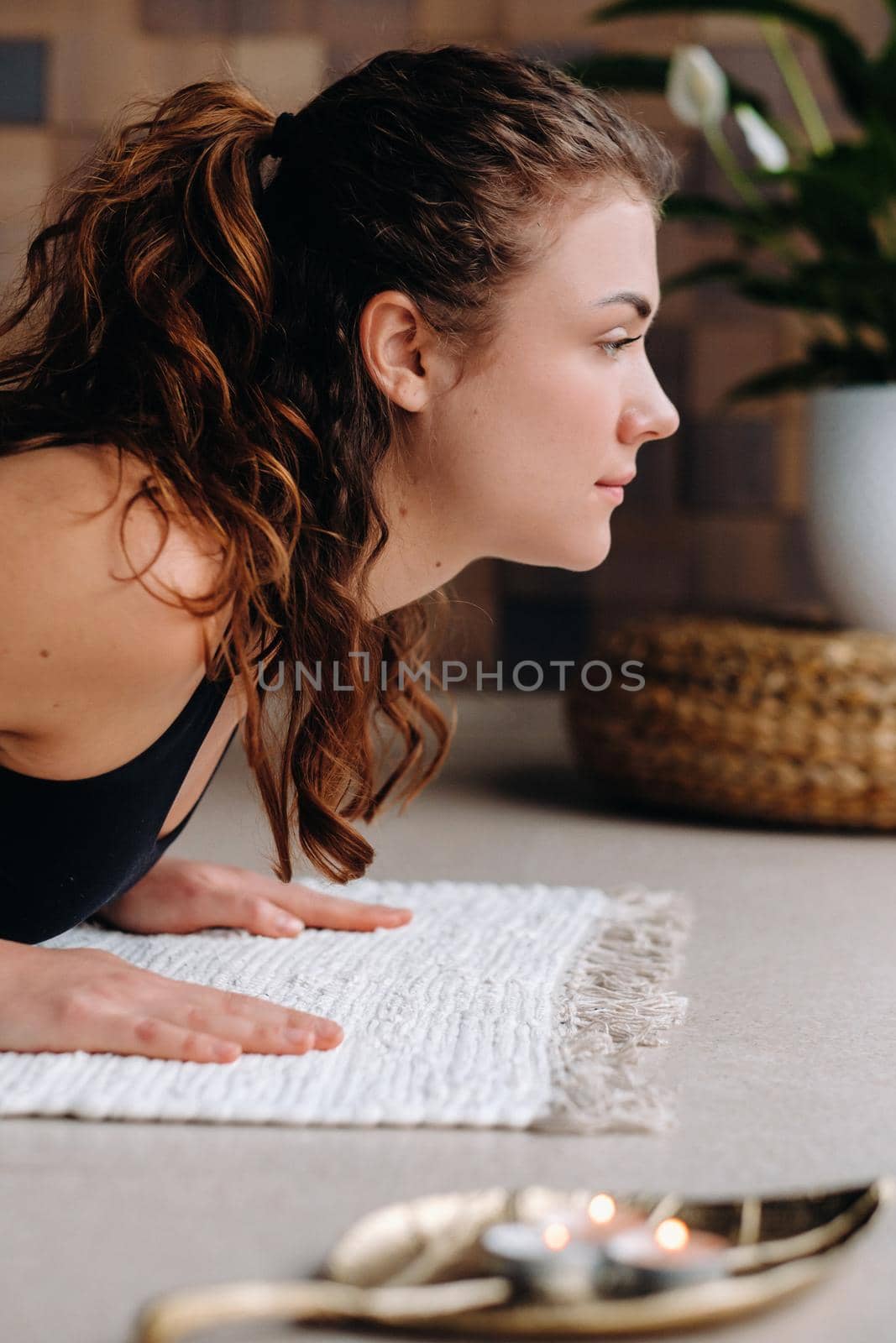 A young woman in black clothes is doing yoga in a modern gym.The concept of health by Lobachad