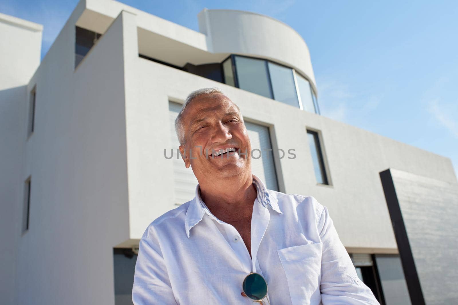 senior man in front of luxury modern home villa