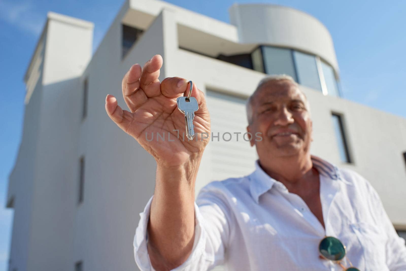 senior man in front of modern home by dotshock