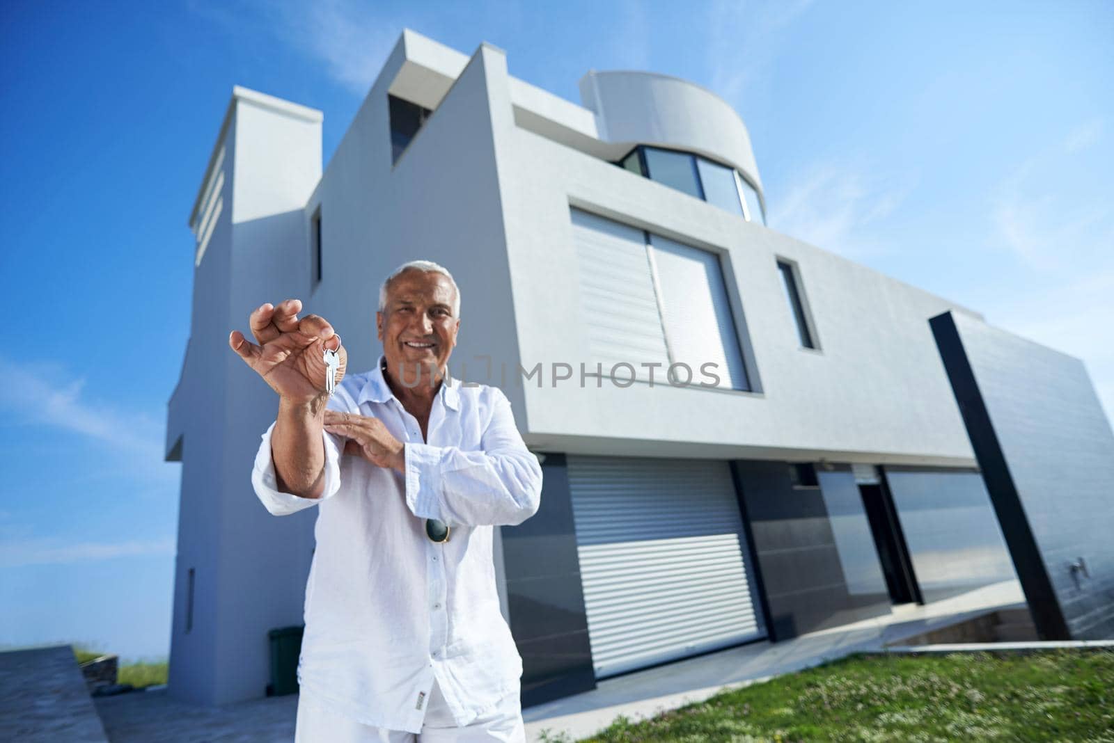 senior man in front of modern home by dotshock