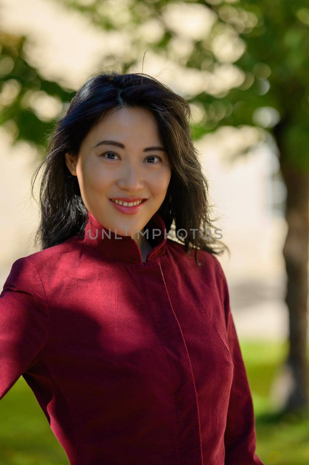 Beautiful chinese woman with long black hair on a sunny autumn day in the city,