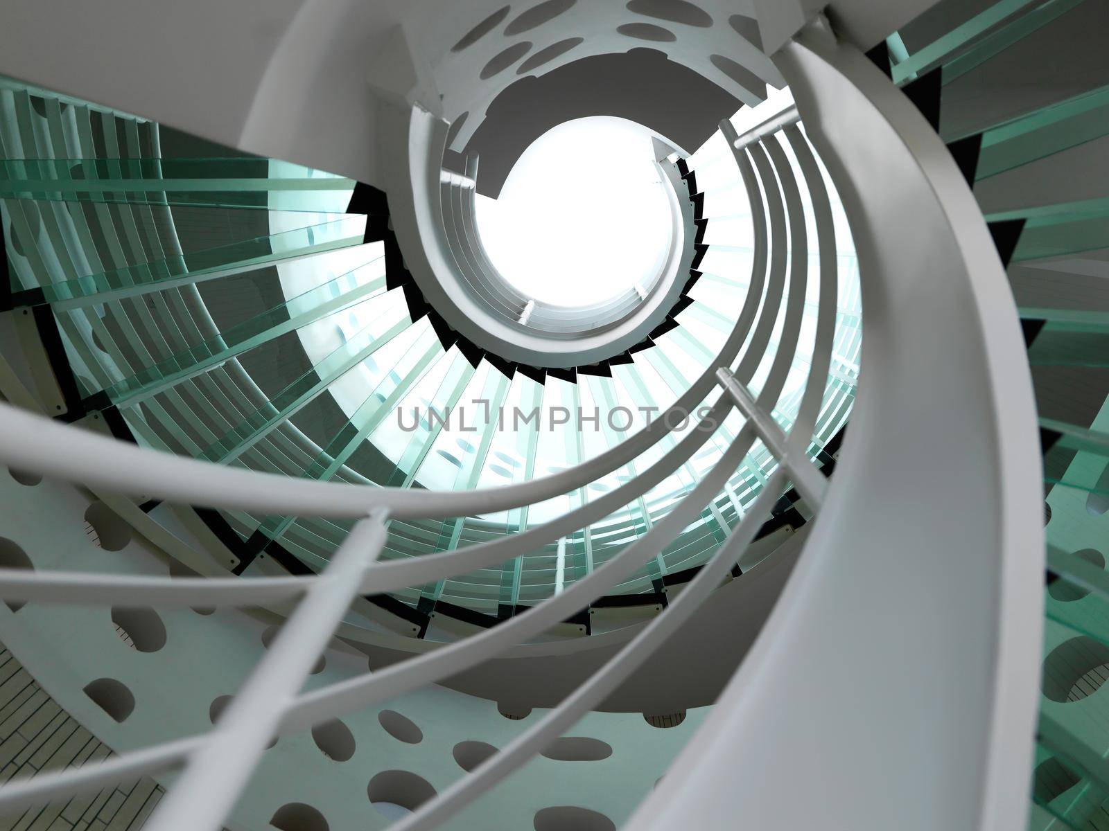 modern glass spiral staircase with metallic hand-rails.