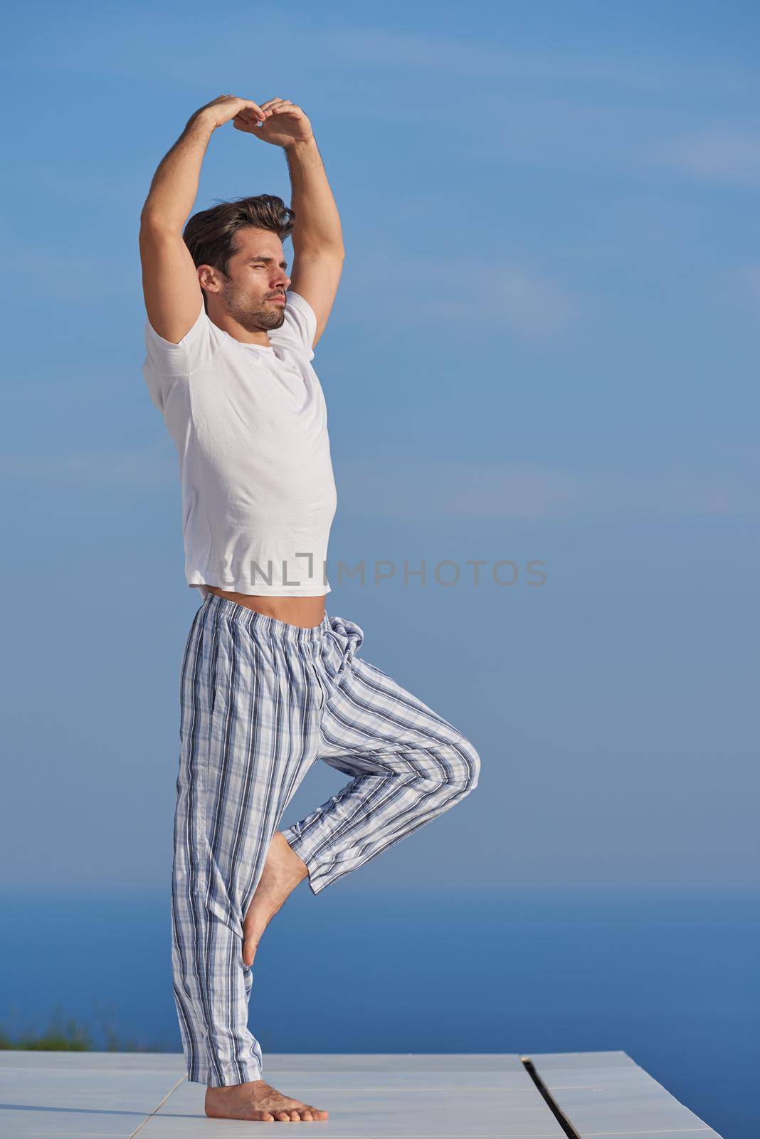 young man practicing yoga by dotshock